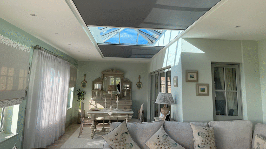 Elegant living-dining space with 2.2m x 9m Twin Athena roof blind with roof lantern above