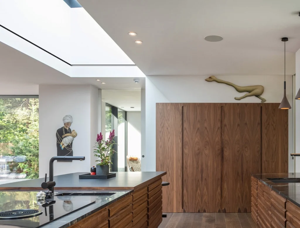A modern kitchen interior with a 4 m skylight above the island, seamlessly integrated into the ceiling. The Athena electric roof blind is fully concealed within a C155 × 255 Blindspace box, with no visible hardware or fixings.