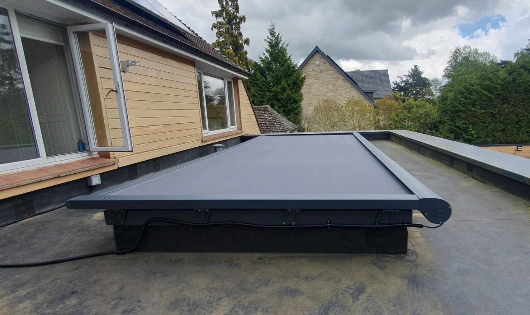 Artemis external roof blind fully extended over a flat skylight on a modern home.