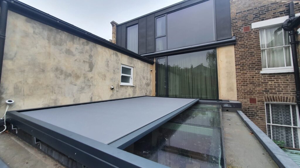 Artemis external roof blind spanning large pitched skylight above kitchen extension, filtering light and heat
