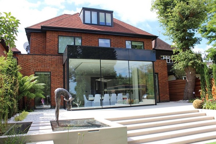 "Modern home with glass extension treated with virtually invisible 3M Prestige 70 film, reducing infrared heat while preserving natural light.