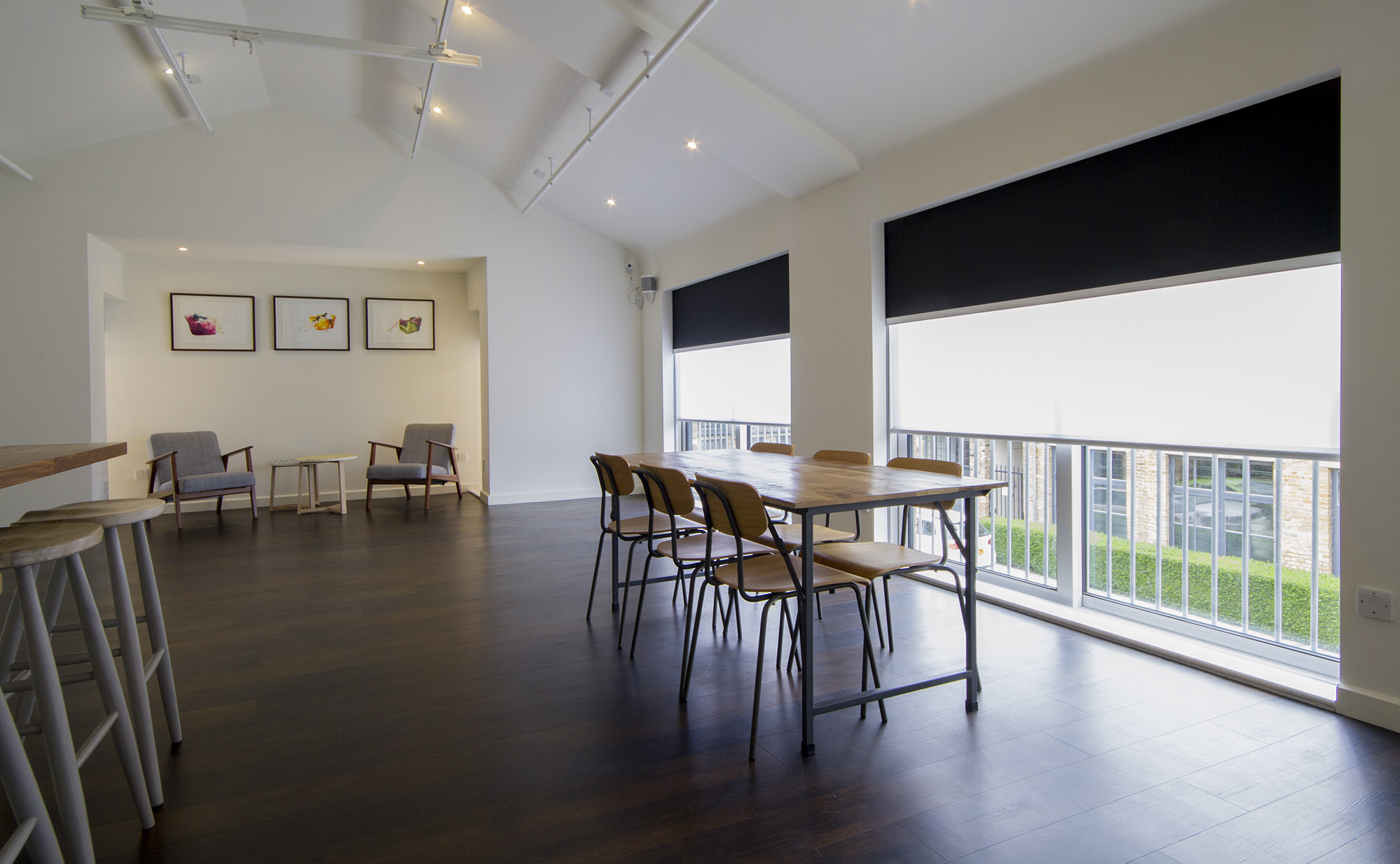 A modern room with large windows featuring concealed dual blinds—sheer and blackout—partially drawn to balance light and privacy.