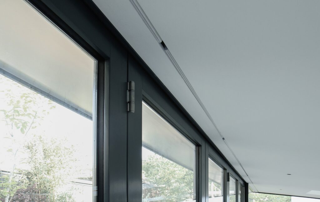 Modern interior with large windows featuring a Blindspace concealed system installed during first fix, hiding all blind hardware for a seamless finish.