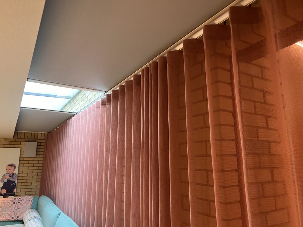 Cinematic room with long skylight fitted with Twin Zeus solar-powered blackout roof blinds.