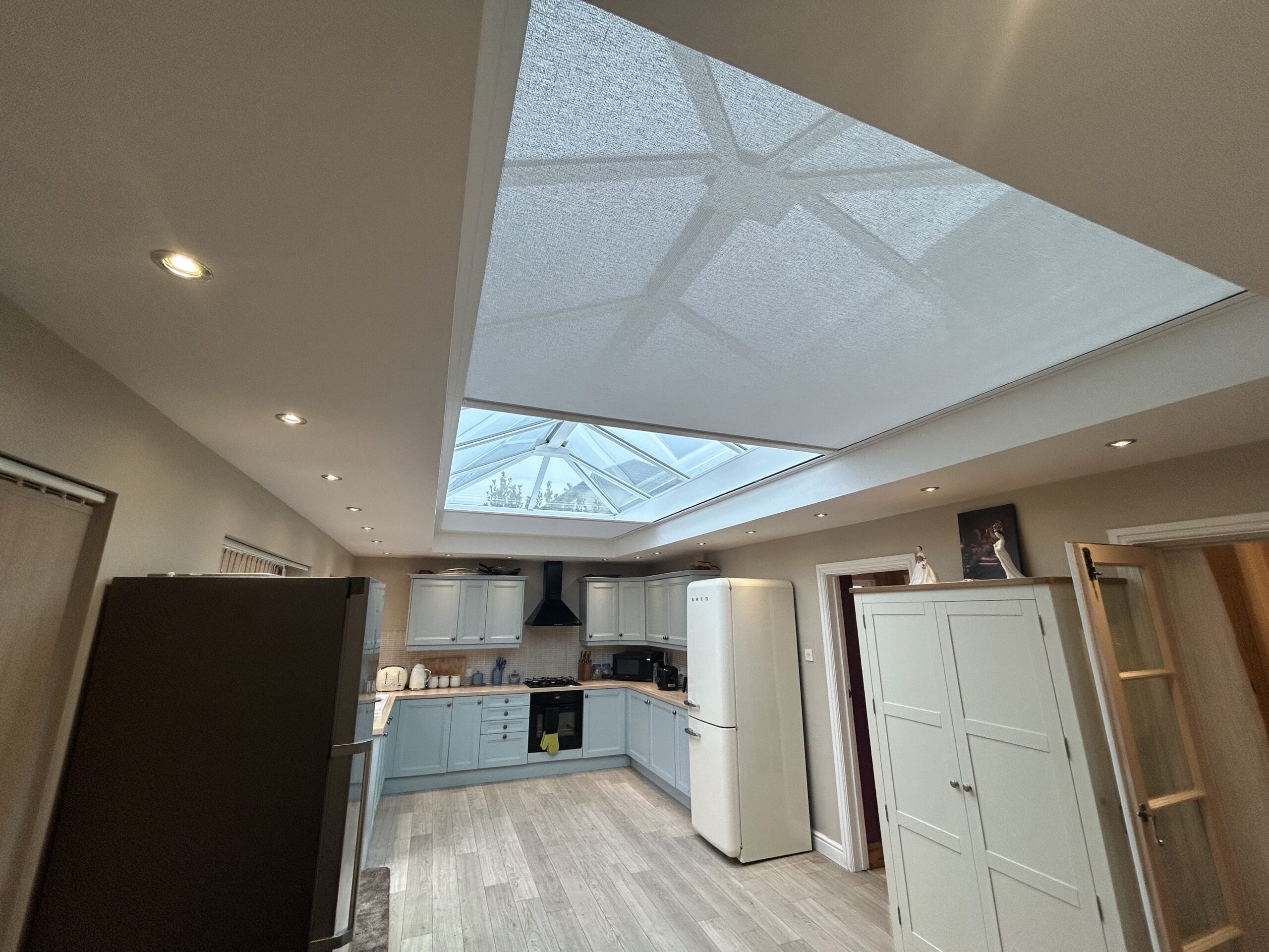 Large electric roof lantern spanning the new extension kitchen, meeting seamlessly in the middle to flood the space with natural light.