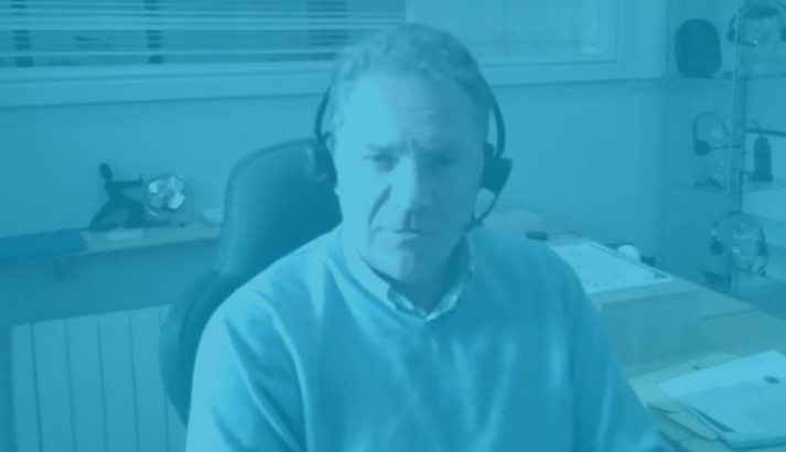 Man seated in a modern office with WindowTreat blue overlay; Blindspace concealed blinds installed in roof lanterns, bifold doors, and windows.