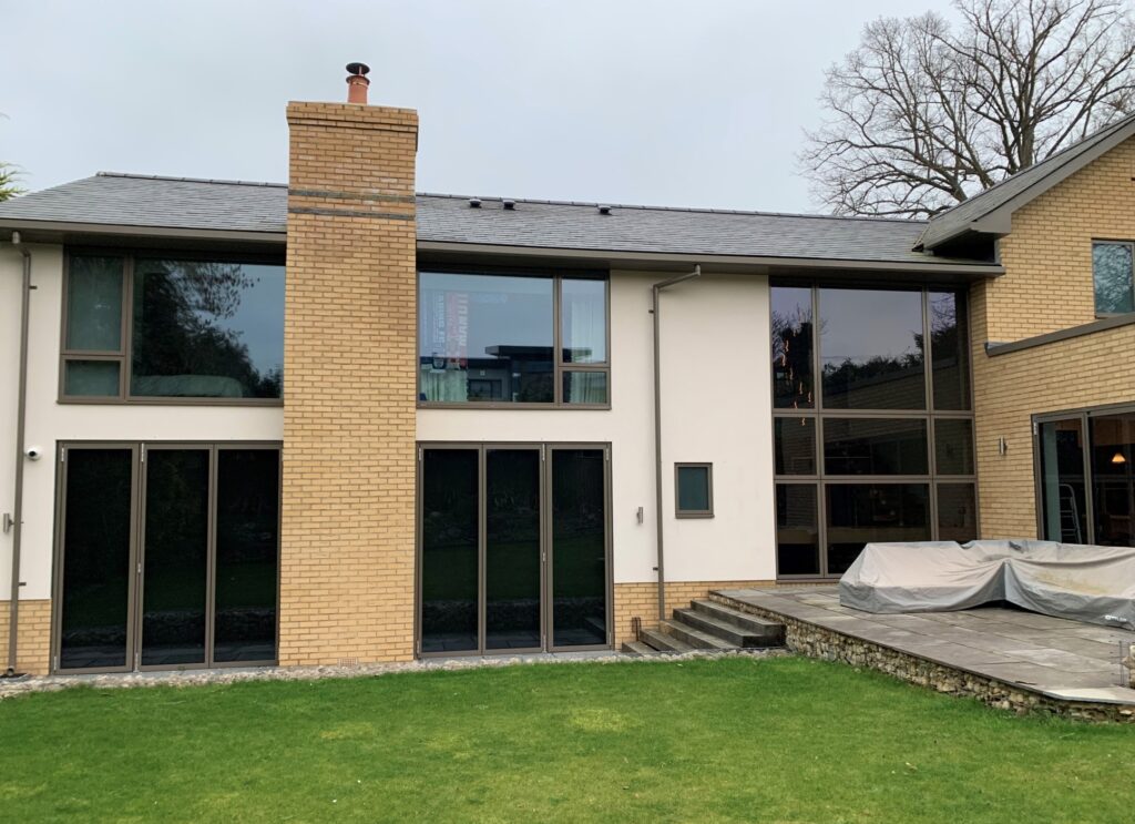 Modern two-story home with large southwest-facing windows treated with 3M Prestige 40 Exterior film to reduce solar heat gain while preserving clear views and architectural transparency.