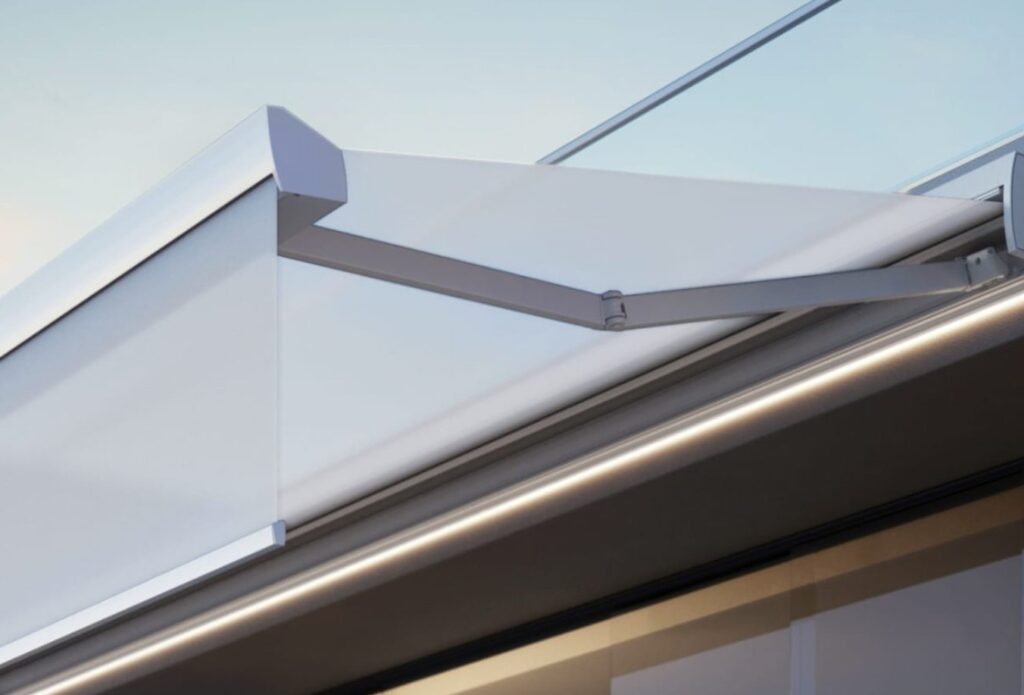 Sol-Elite multi-fix retractable awning with electric drop-down valance, mounted above glass façade for dynamic sun control.