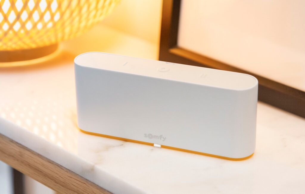 omfy TaHoma Switch hub with yellow accent on marble surface