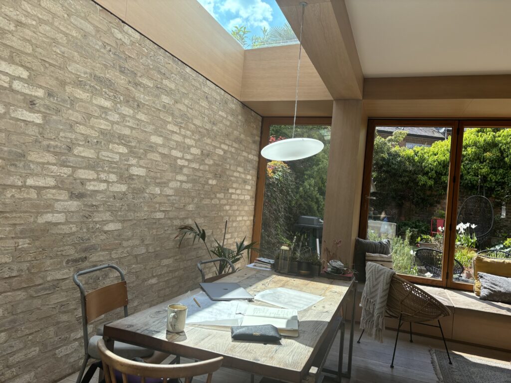 nterior view of the family table beneath the side return glazing with natural light filling the space.
